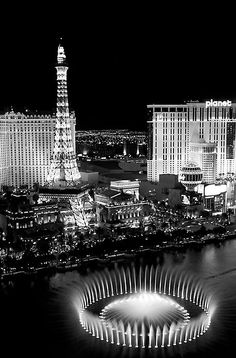 black and white photograph of las vegas at night with the eiffel tower in the background