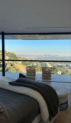 a large bed sitting in the middle of a bedroom next to a tall glass wall