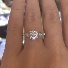 a woman's hand with two engagement rings on it