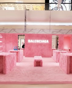 the interior of a fashion store with pink walls and benches in front of it that read balenciaa