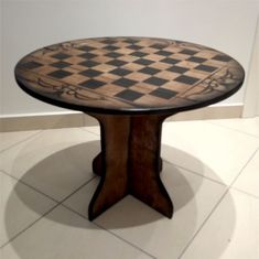 a chess board table sitting on top of a tile floor next to a white wall