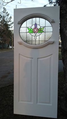 a white door with a stained glass window in the top half and bottom half,