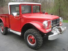 an old red truck parked in a parking lot