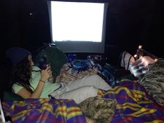 a woman laying in bed watching tv at night