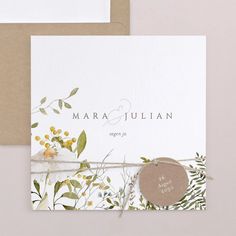 the wedding card is decorated with watercolor flowers and greenery, which are tied in twine