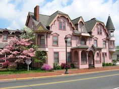 a large pink house sitting on the side of a road