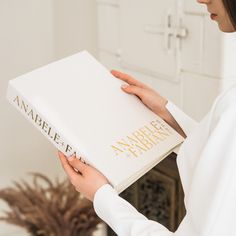 a woman is holding a book in her hands