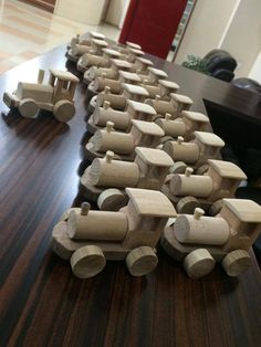 wooden toy trains are lined up on a table