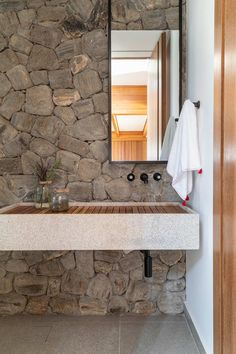 a bathroom with stone walls and a wooden sink