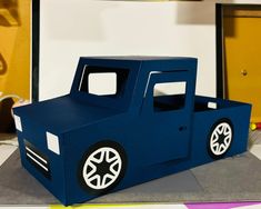 a paper model of a blue truck with white wheels