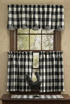 a black and white checkered window curtain with a rooster figurine on top