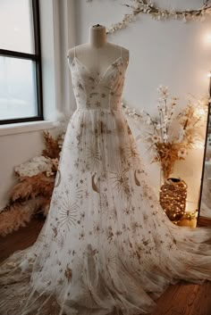 a dress is on display in front of a window with lights and decorations around it