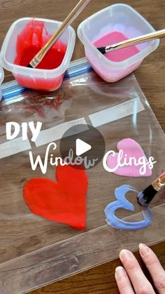 someone is painting hearts on a piece of clear acrylic that says diy window clings