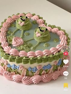 there is a cake decorated with green and pink icing on the table, it looks like an alien