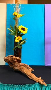 a vase filled with yellow flowers sitting on top of a black tablecloth covered table