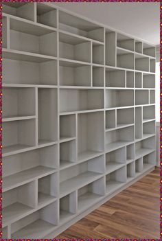 an empty white bookcase with lots of shelves