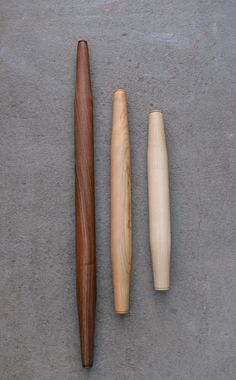 three different types of wooden objects on a concrete surface, including a baseball bat and a mallet