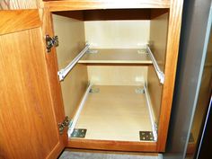 an empty wooden cabinet with metal handles