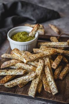 french fries on a cutting board with dipping sauce