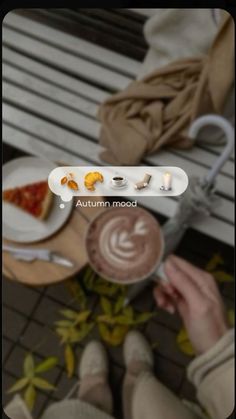 a person sitting on a bench holding a cup of coffee and looking down at the ground