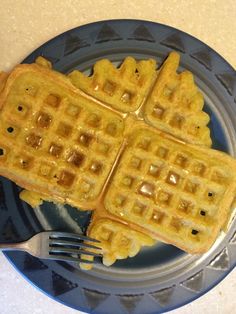 three waffles on a plate with a fork