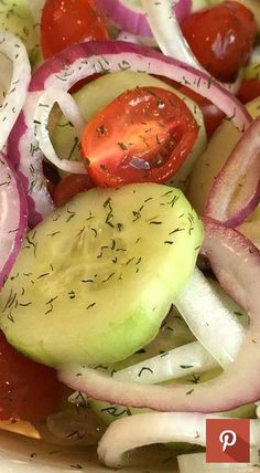 a salad with onions, cucumbers and tomatoes on it is ready to be eaten