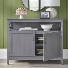 a gray cabinet with a mirror above it and a cake on the table next to it