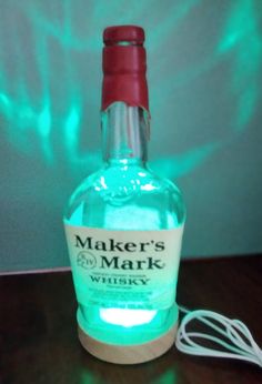 a bottle of maker's mark whiskey sitting on top of a table next to an electric cord