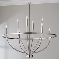 a large chandelier with six lights hanging from it's center point in a room