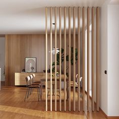 an open living room and dining area with wooden slats on the wall in front of it