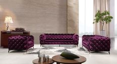 a living room filled with purple couches next to a coffee table and vases