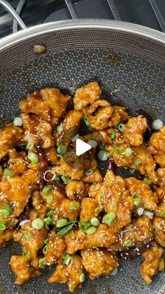 chicken with sesame seeds and green onions in a frying pan