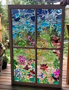 a stained glass window sitting on top of a wooden deck