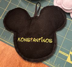 a close up of a mickey mouse head on a table with sewing rulers and scissors