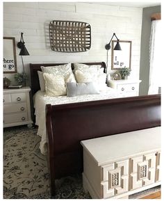 a bed room with a neatly made bed and dressers on either side of the bed