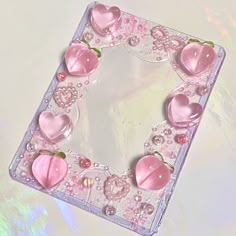 a pink heart shaped object on top of a glass plate with other items around it