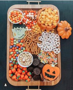 a wooden tray filled with halloween treats and candy