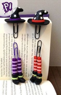 three little witches are sitting on top of an open book with paper clips attached to them