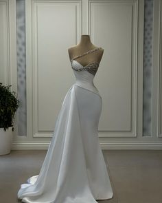 a white wedding dress on display in a room