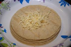 three tortillas on a plate topped with shredded cheese