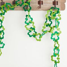 green and white streamers are hanging from a coat rack on a wooden hanger