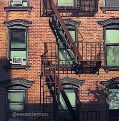 a fire escape on the side of a brick building with windows and balconies