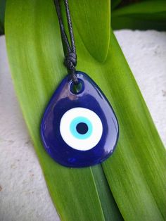 Clear Blue glass stained with indigo blue color, painted evil eye pendant. Necklace is adjustable with a black cord Blue Evil Eye Necklace, Alien Face, Eye Glass, Raw Amethyst, Lace Headbands, Blue Evil Eye, Eye Pendant, Evil Eye Pendant, Evil Eye Charm