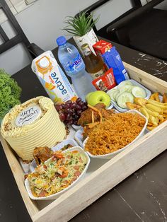 a wooden tray filled with different types of food and drinks on top of a table