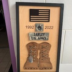 a shadow box with an army boot and american flag on the wall next to it