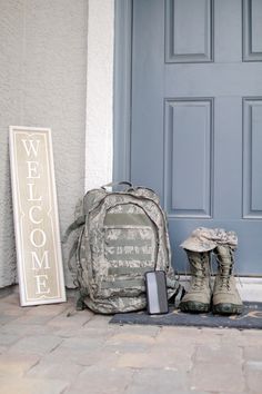 a backpack, cell phone and boots sitting on the ground in front of a door