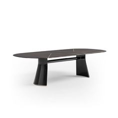 a black table with an oval shaped top and two curved legs, in front of a white background