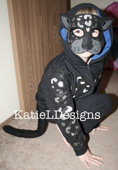 a young child wearing a cat costume on the floor