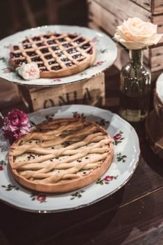 three plates with pies on them and flowers in vases next to each other