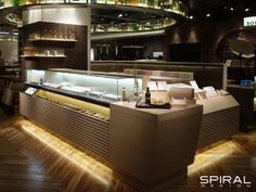 an empty restaurant with lots of bottles on the counter and shelves filled with food items